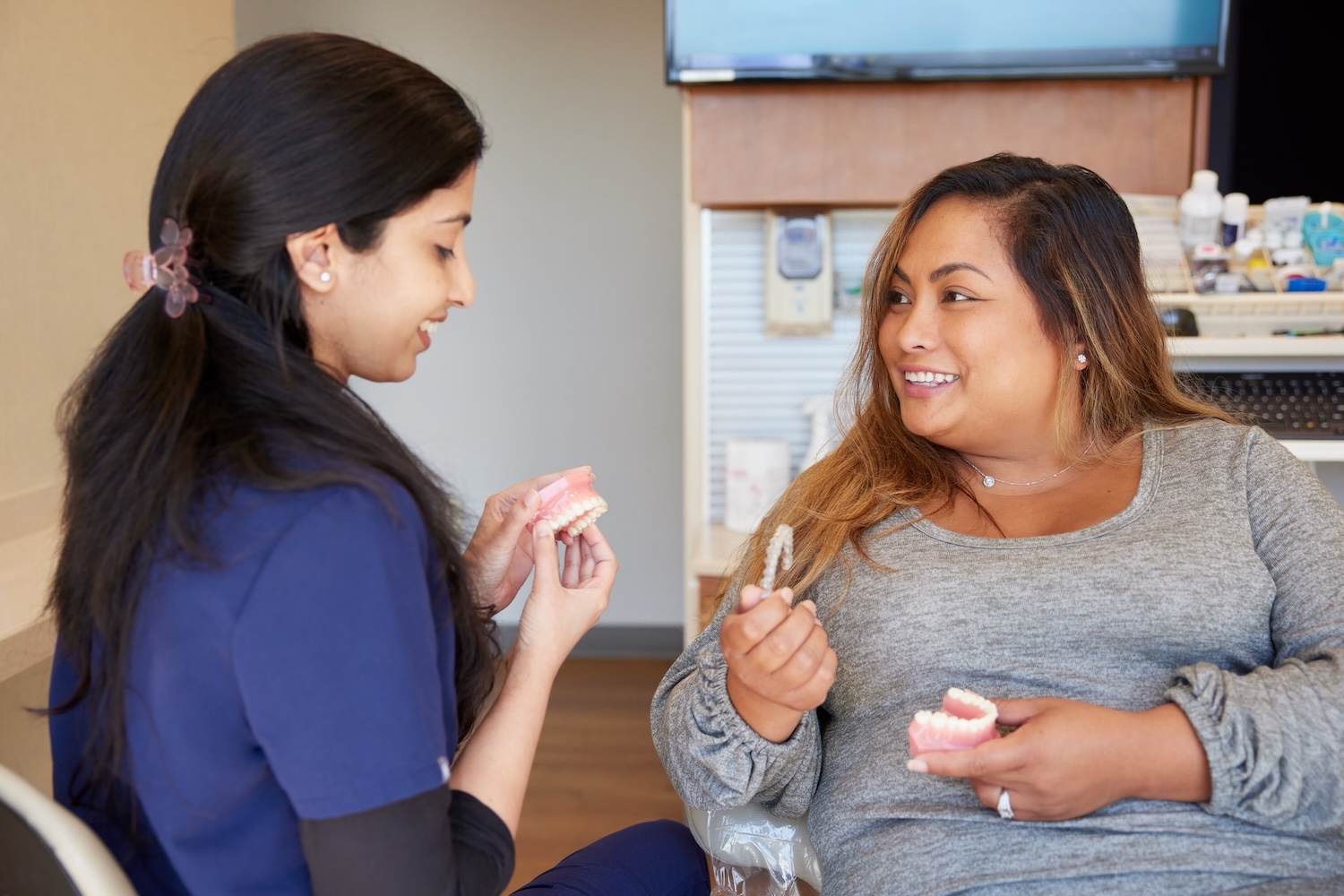 dental provider with patient discussing cleaning invisalign trays