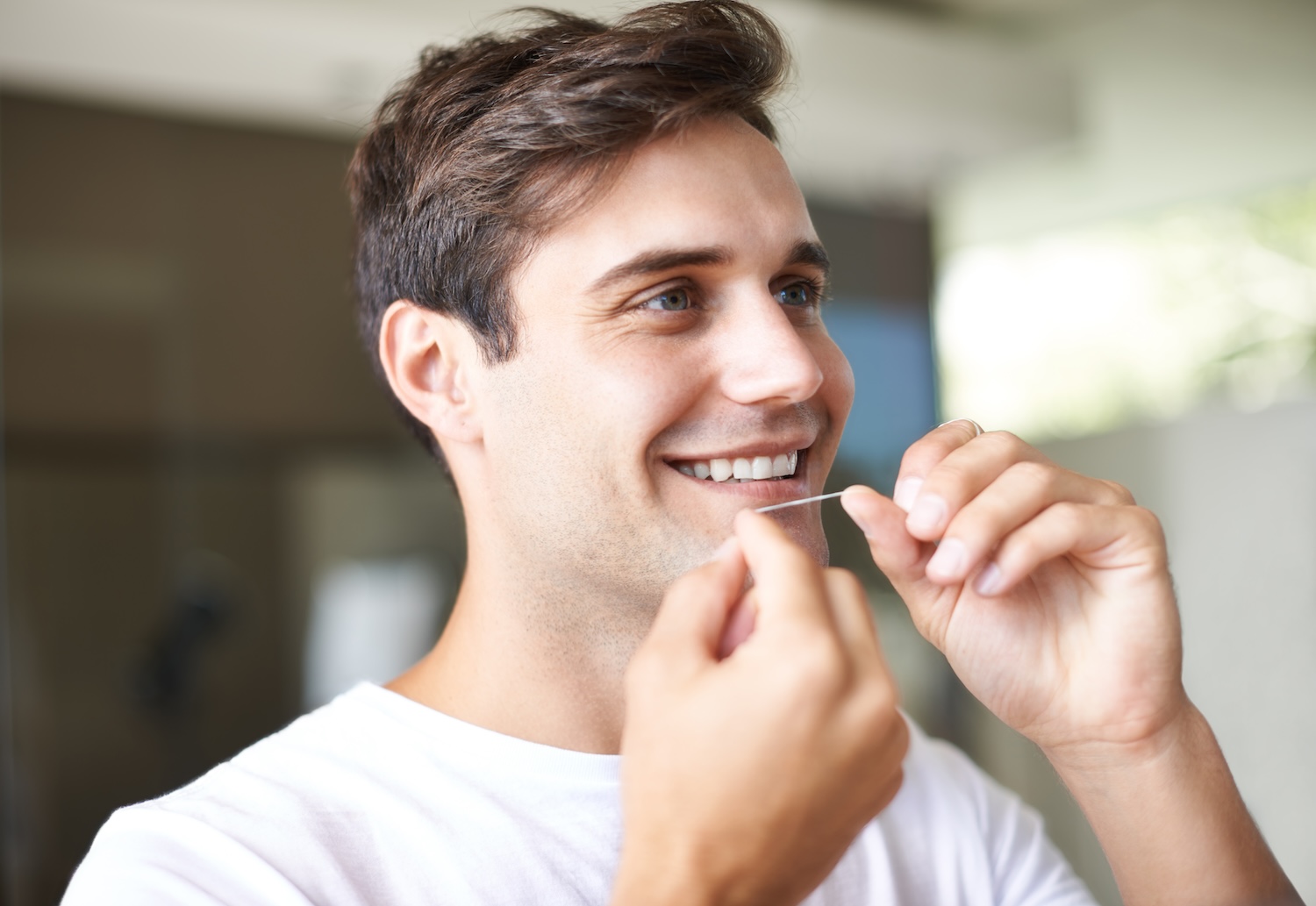 young man flossing his teeth